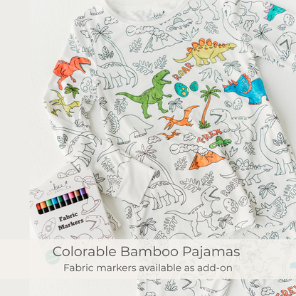 Colorable bamboo pajamas with dinosaur patterns and fabric markers on a white background