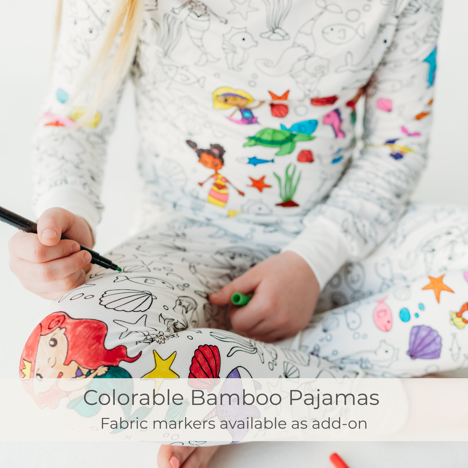 Kid coloring mermaid print coloring pajamas with fabric markers. 