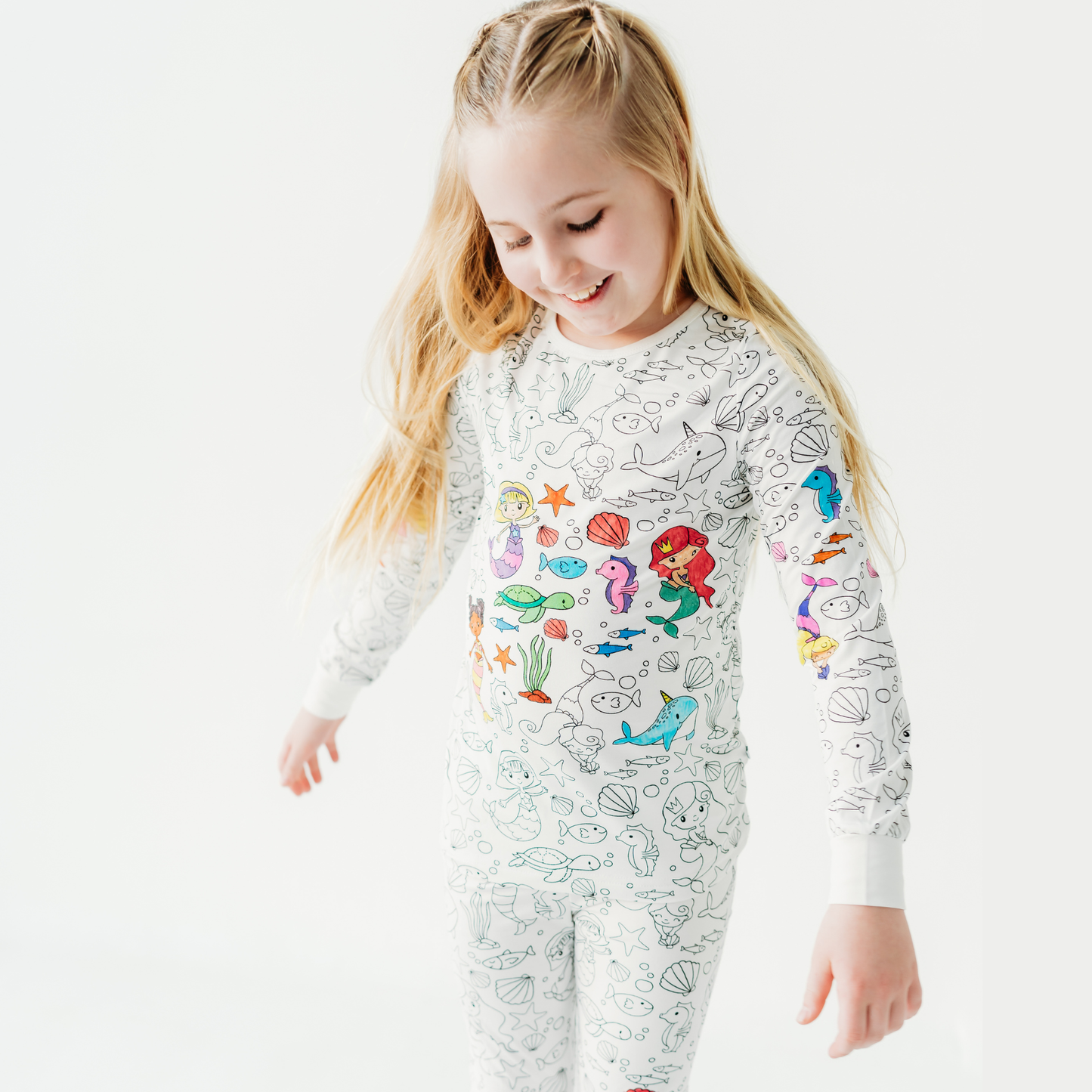 Girl wearing mermaid coloring pajamas set made from soft bamboo