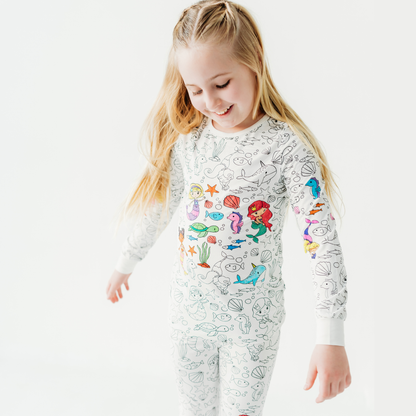 Girl wearing mermaid coloring pajamas set made from soft bamboo